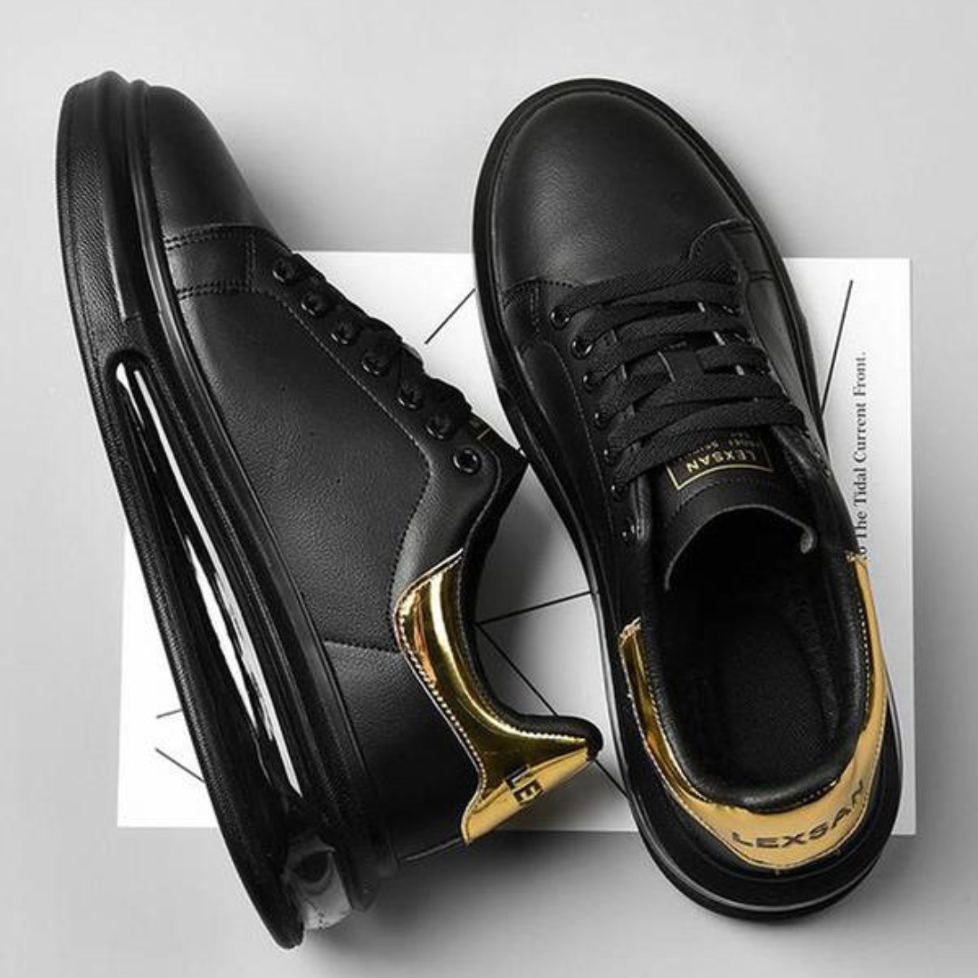 Zapatillas de cuero negro con detalles dorados y suela deportiva