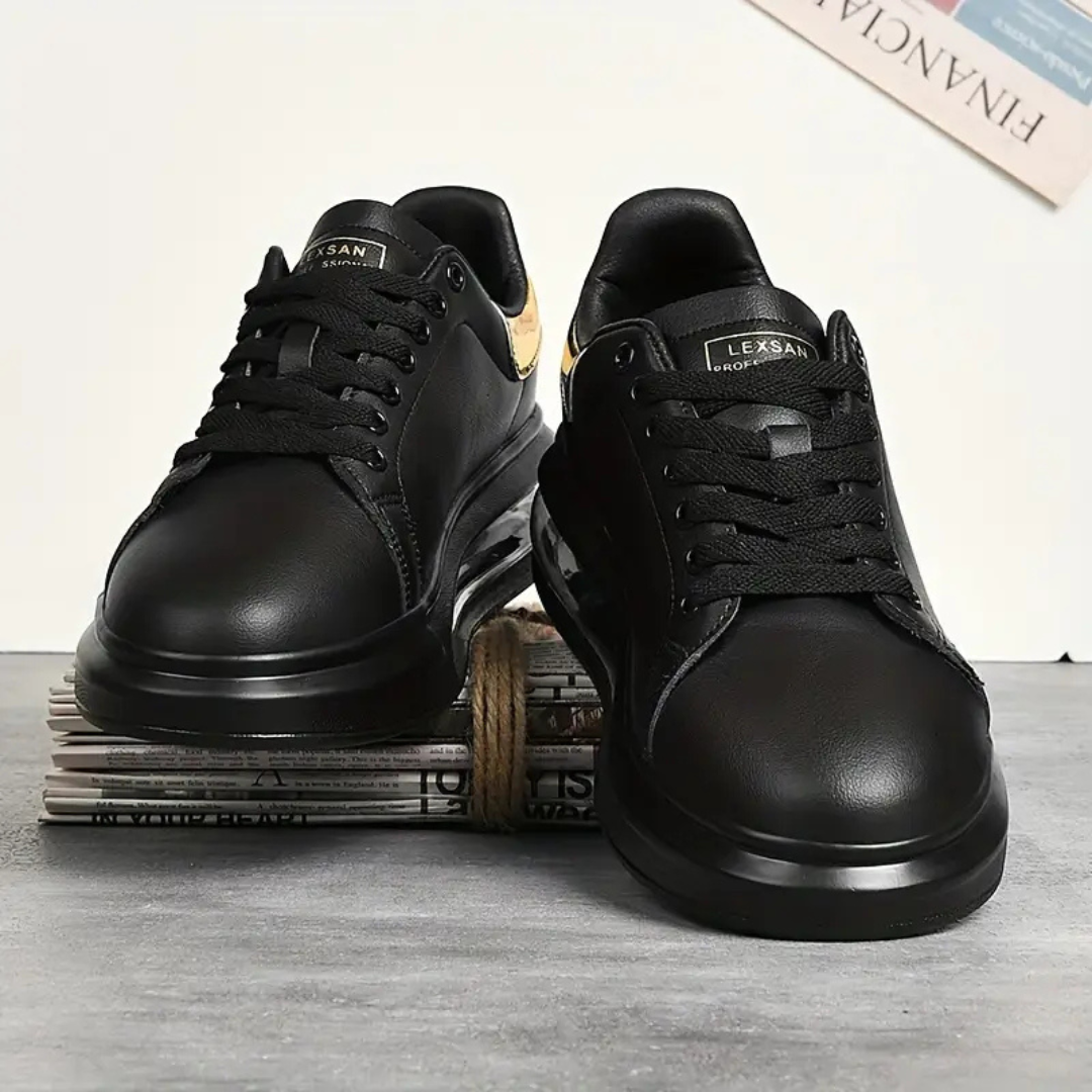 Zapatillas de cuero negro con detalles dorados y suela deportiva