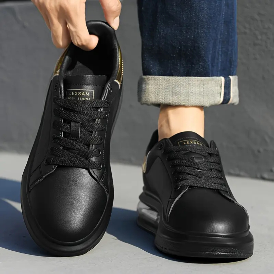 Zapatillas de cuero negro con detalles dorados y suela deportiva