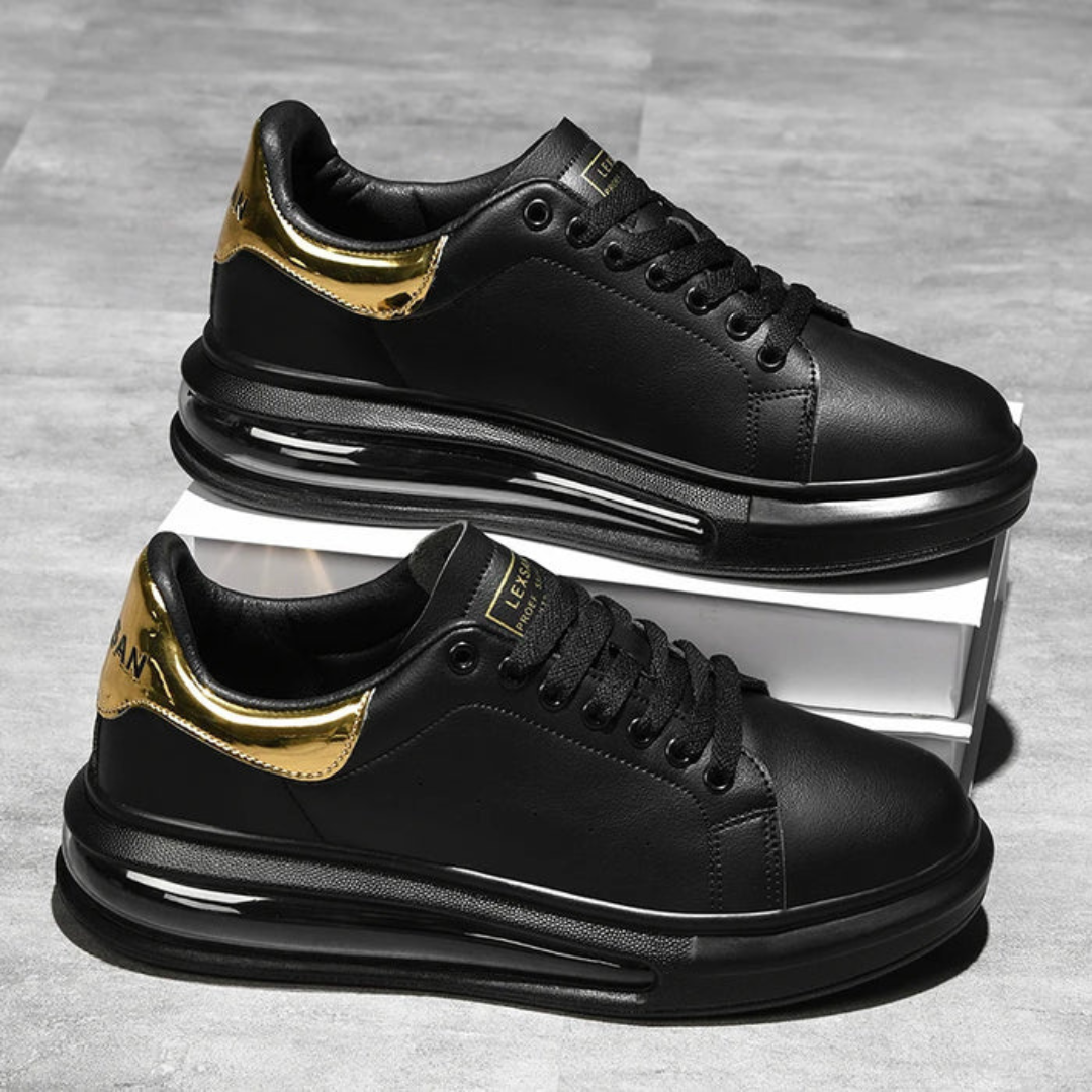 Zapatillas de cuero negro con detalles dorados y suela deportiva