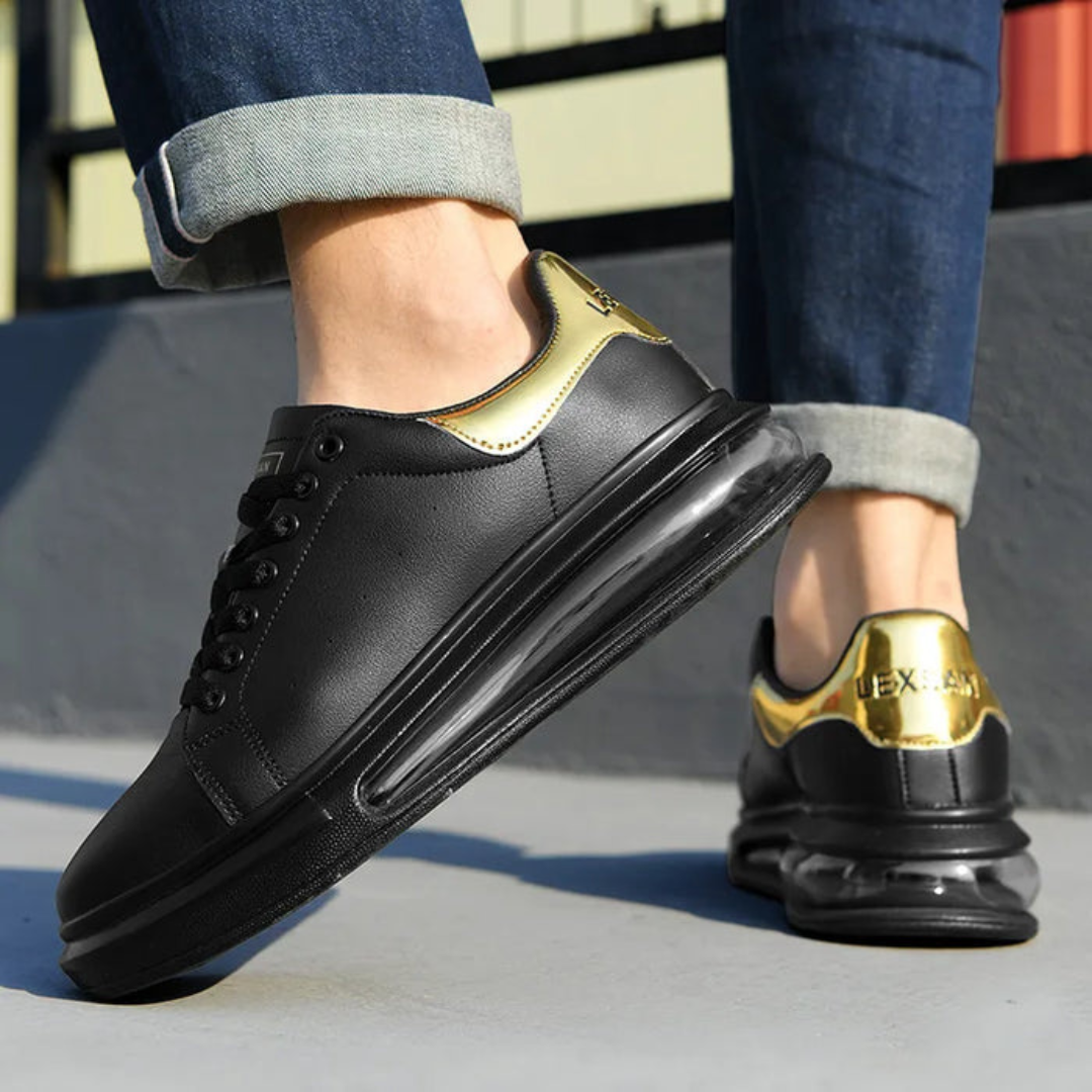Zapatillas de cuero negro con detalles dorados y suela deportiva