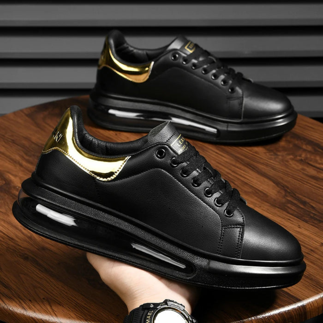 Zapatillas de cuero negro con detalles dorados y suela deportiva